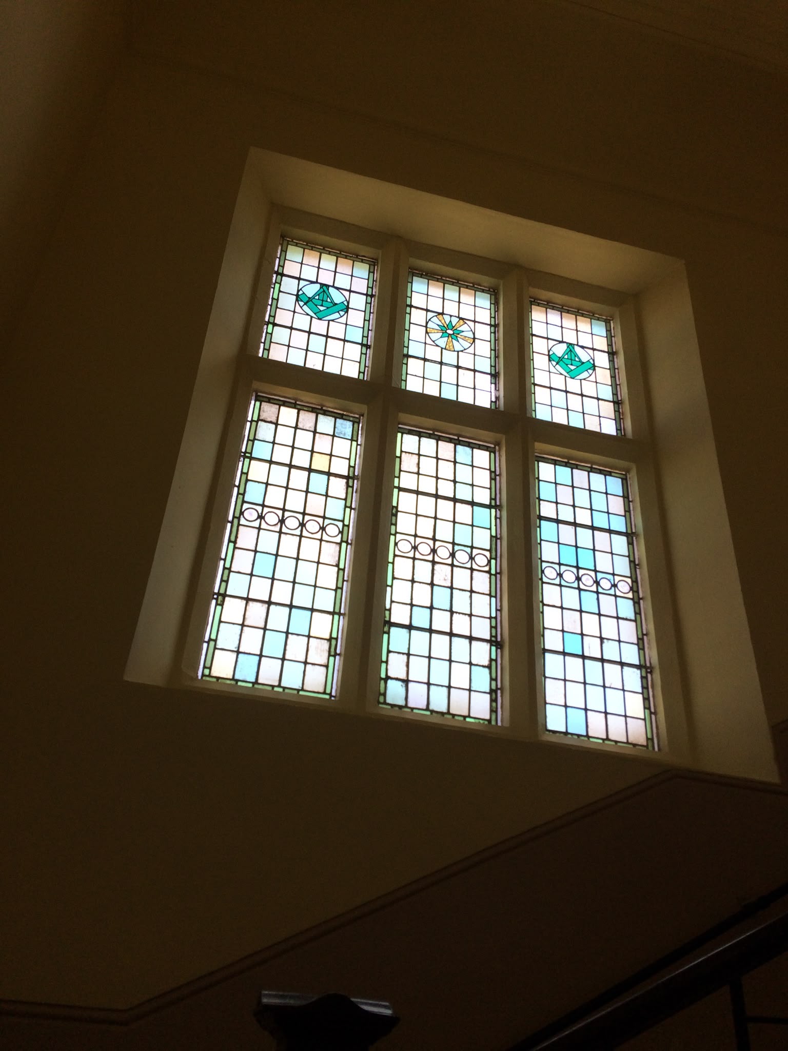 Painted interior walls around a stained glass window.