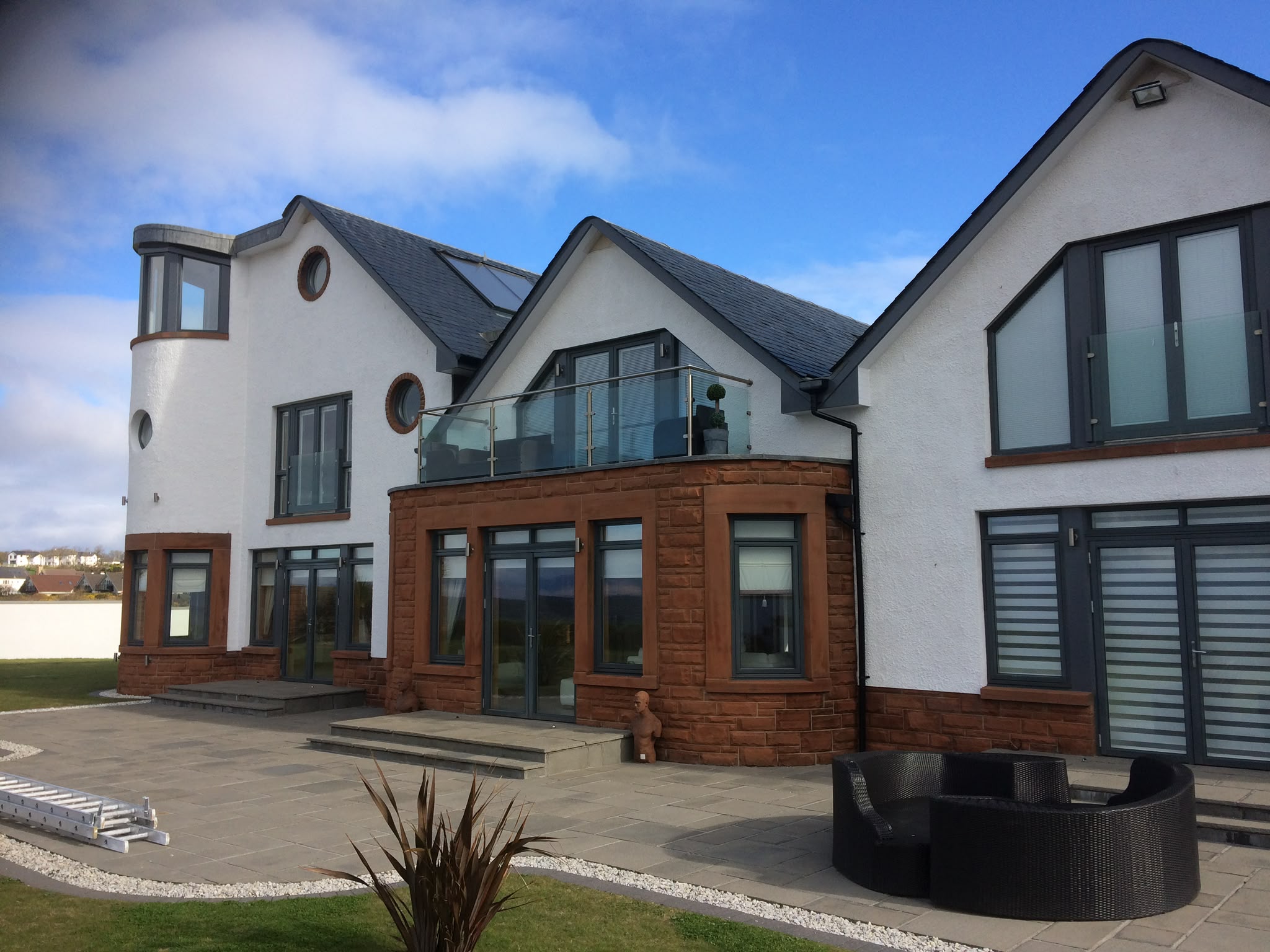 White-painted render and grey window frames on a house.